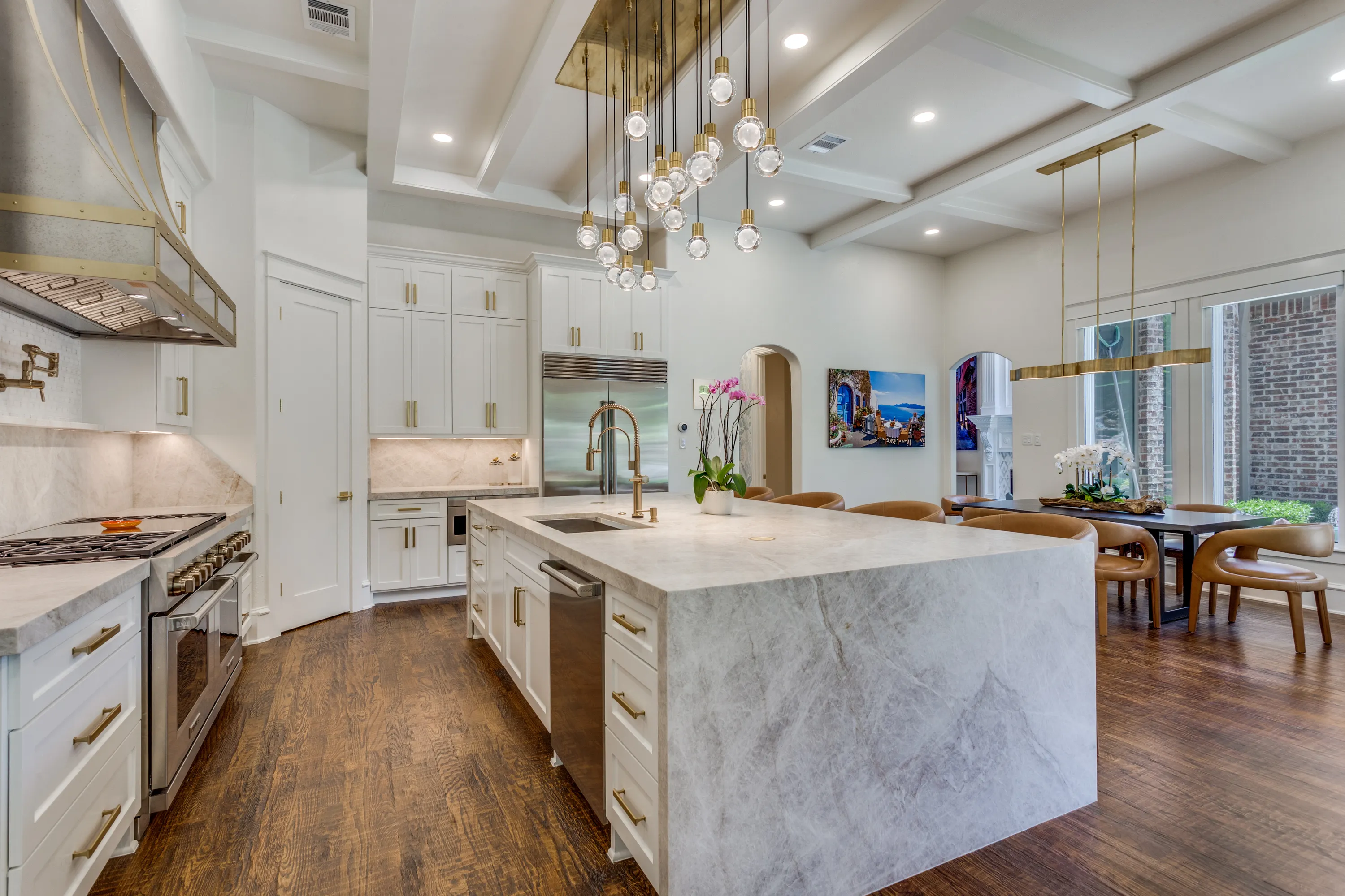 Range wall with Taj Mahal quartzite backsplash and pot filler, dining area beyond