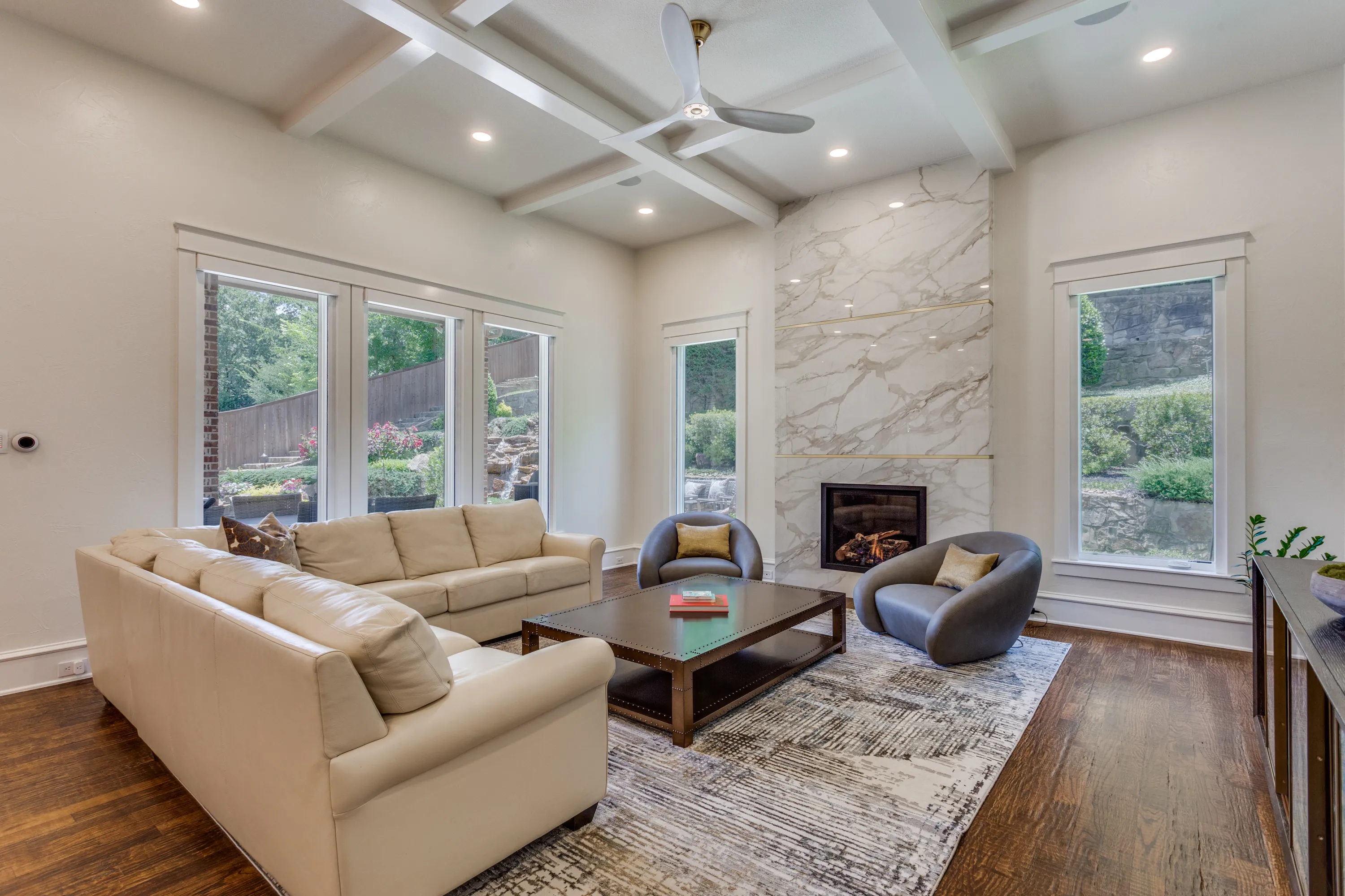 Family room with new floor-to-ceiling porcelain fireplace and swivel chairs