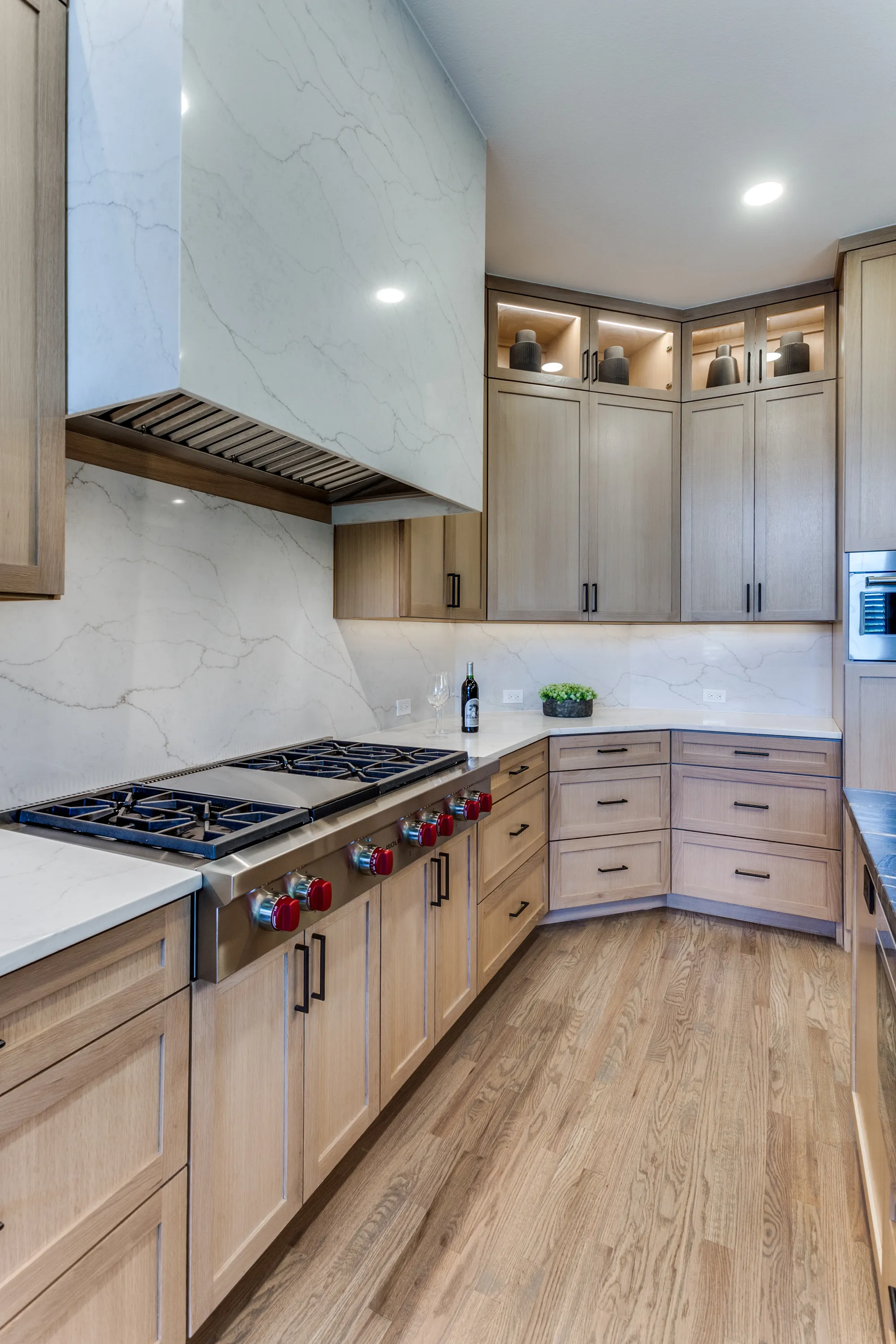 Wolf cooktop and corner cabinetry with illuminated display niches