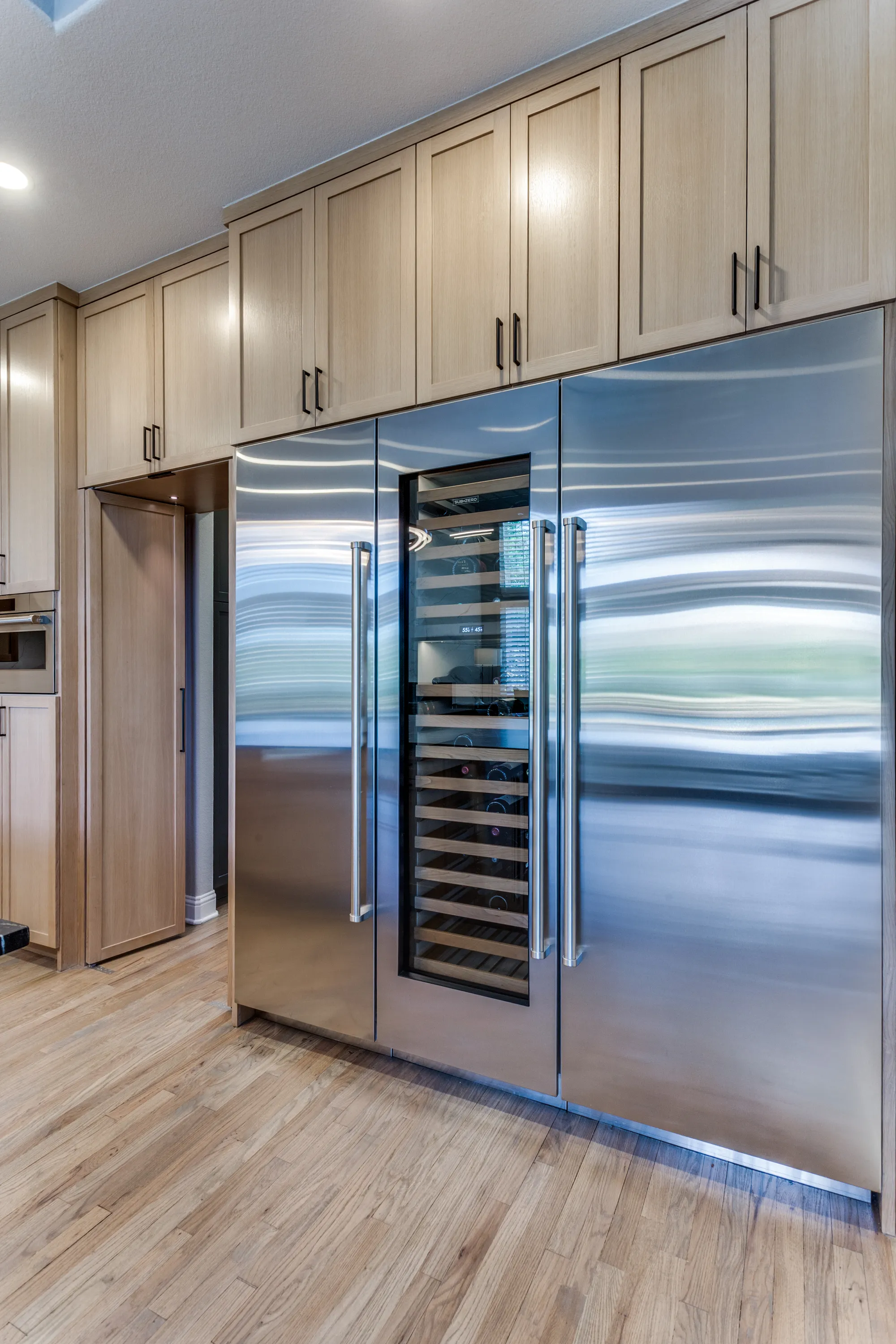 Built-in Sub-Zero refrigerator and freezer towers flanking the wine column