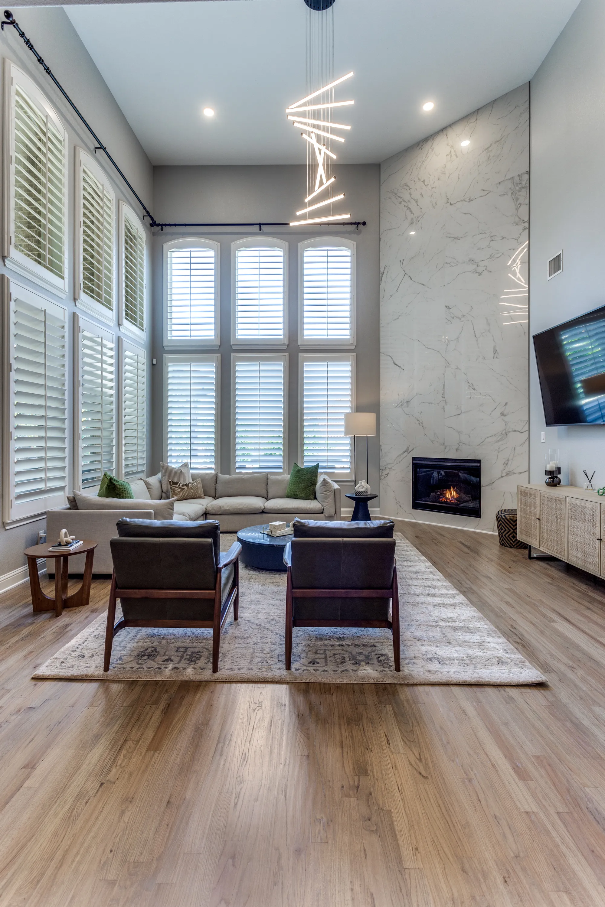 Two-story family room with a full-height fireplace wall in large-format porcelain tile