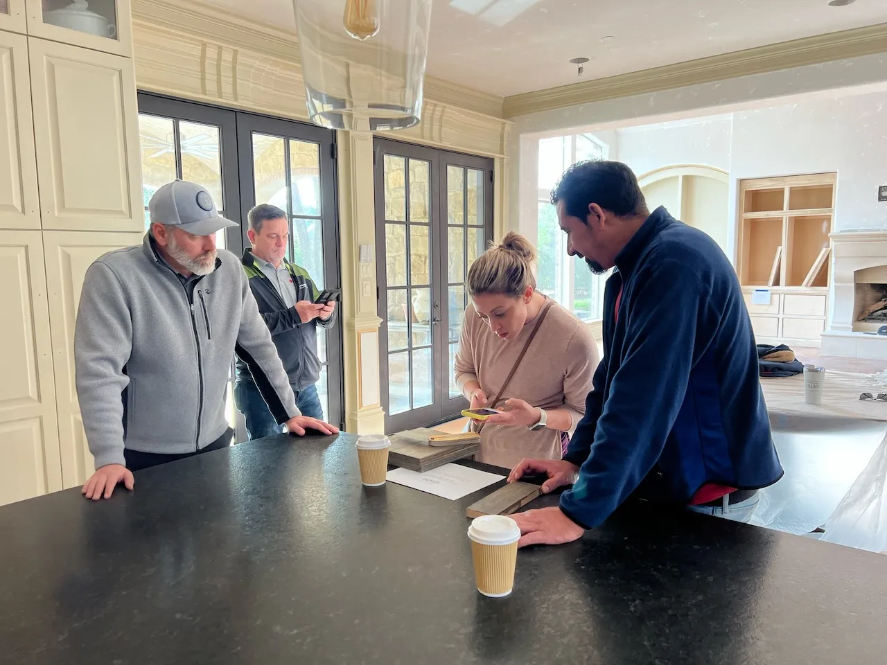 Chad at a Southlake island reviewing materials with a homeowner and her interior designer — the exact designer-plus-builder-partnership the article compares to design-build.