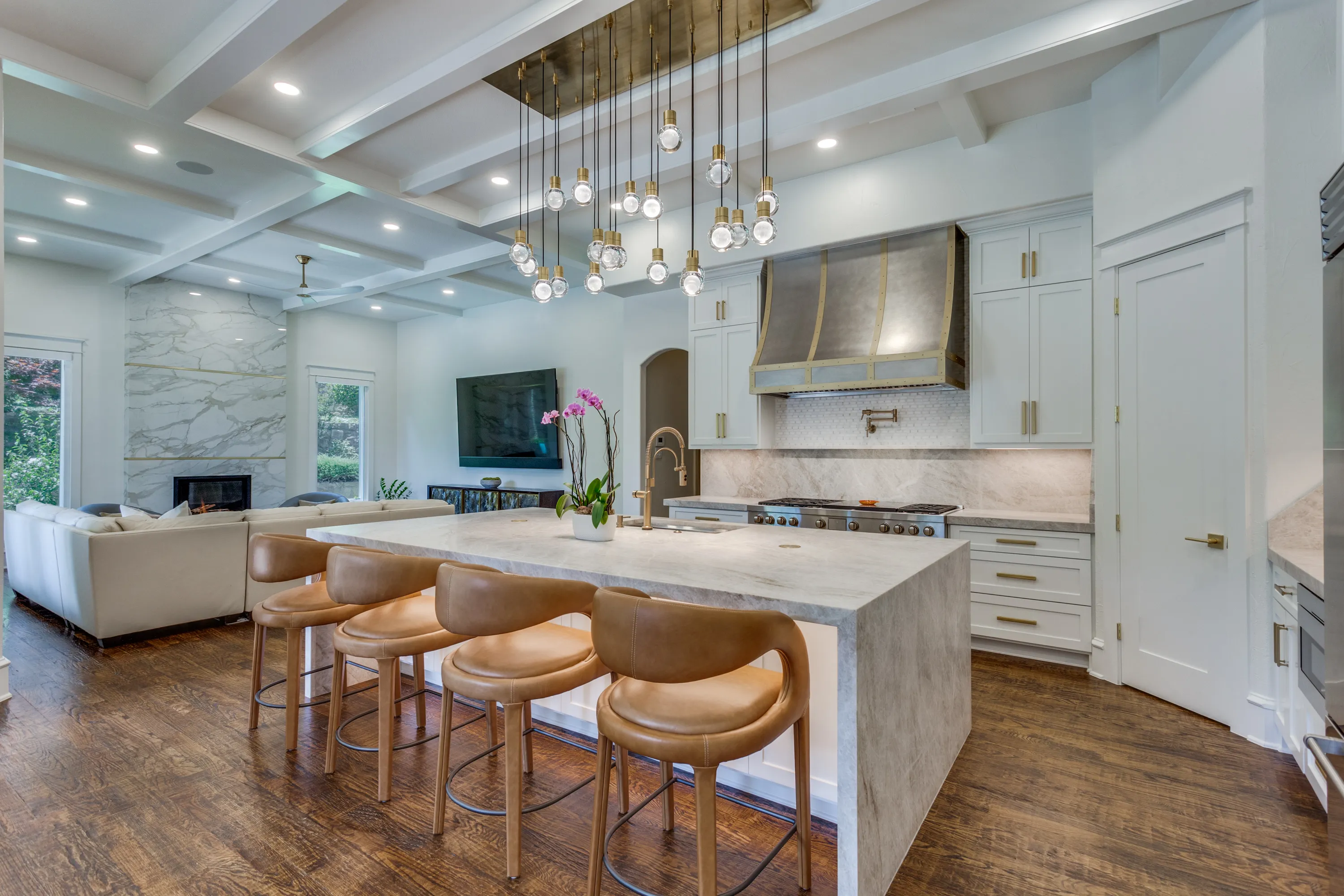 Keller Kitchen Renovation — waterfall Taj Mahal quartzite island, custom brass-banded range hood, and 21-light Visual Comfort pendant by Swanson Renovations
